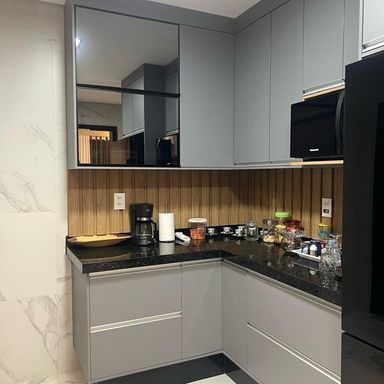 cozinha padrão americana em porcelanato, com armários planejados de primeiríssima qualidade, ampla pia em granito preto