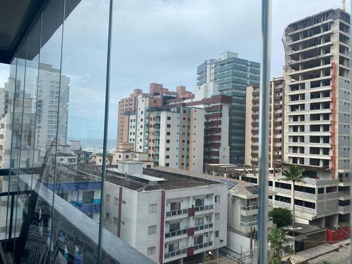 varanda gourmet envidraçada com cortina blackout e vista privilegiada para o mar