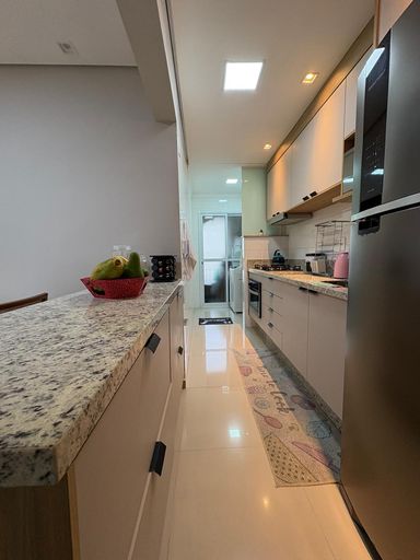 cozinha com armários planejados semi integrada a área de serviço