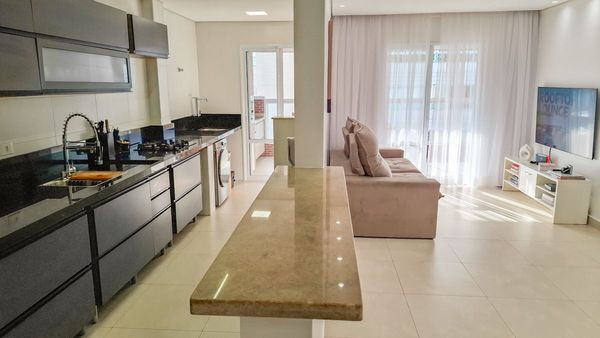 ampla sala 2 ambientes semi integrada a cozinha e a área de serviço, com acesso a varanda gourmet