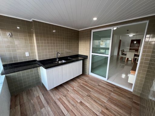 ampla varanda gourmet envidraçada com cortina blackout, acesso a sala 2 ambientes e a suíte