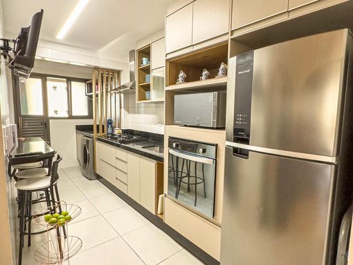 cozinha com armários planejados de primeiríssima qualidade, ampla pia em granito preta, semi integrada a área de serviço e a área técnica