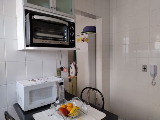 cozinha bem arejada com armários planejados e acesso a área de serviço