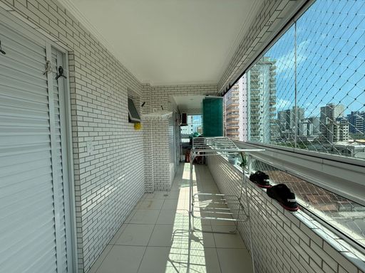 ampla varanda gourmet envidraçada, tela de proteção e com acesso a suíte e a área de serviço