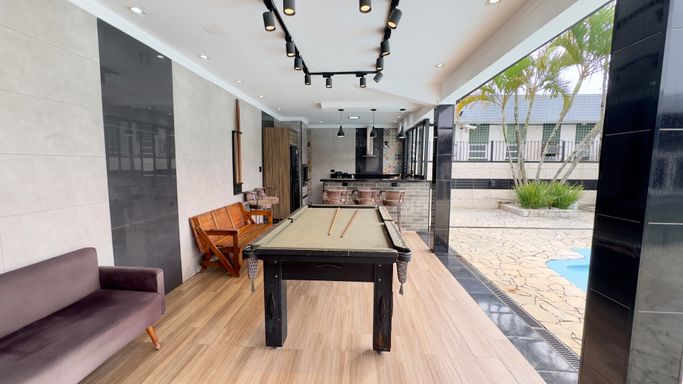 espaço gourmet, com mesa de bilhar, churrasqueira, cozinha completa, 2 banheiros externos, com vista para a piscina.
