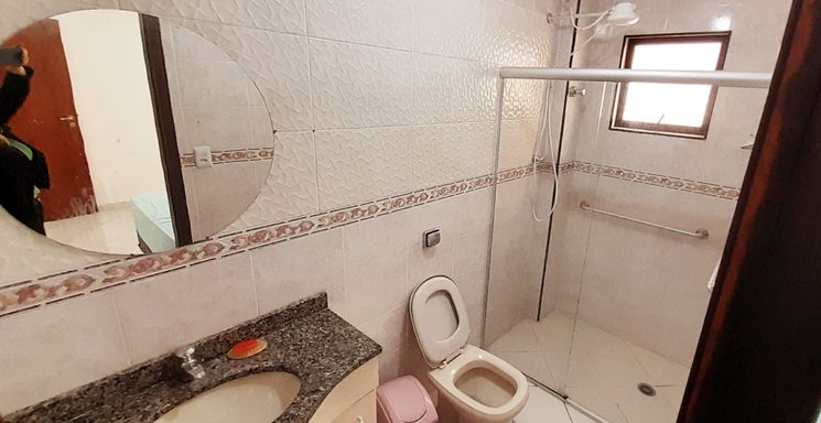 banheiro da suíte com ventilação natural, armário planejado e box blindex