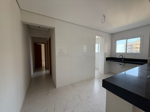 ampla cozinha americana com pedra e balcão em granito preto, acesso a área de serviço e aos dormitórios