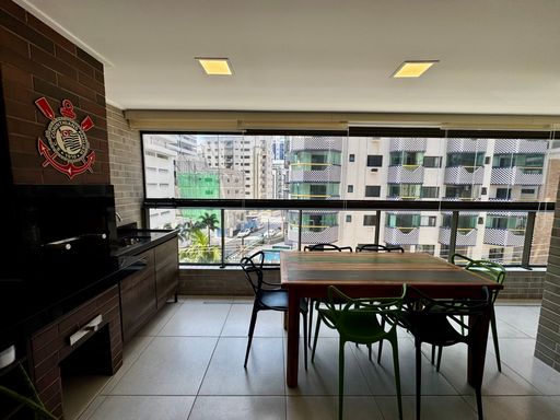 ampla varanda gourmet envidraçada com vista mar privilegiada, churrasqueira a carvão e cortina blackout