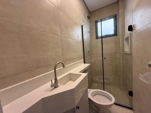 banheiro da suíte 2 com planejado, box de vidro e nicho, bem arejado