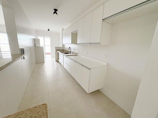 Cozinha ampla com armários planejados, semi integrada a área de serviço e a varanda envidraçada