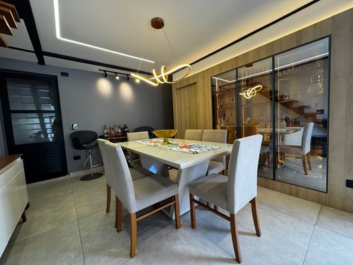 sala de jantar na cobertura com cristaleira impecável com sistema de iluminação em Led, acesso privado na mobília para a área de serviço e ao mesanino