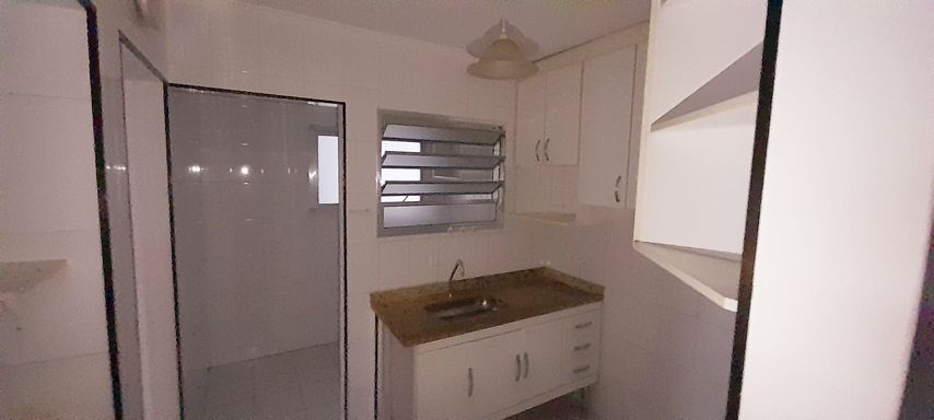 ampla cozinha com armários planejados com acesso a área de serviço