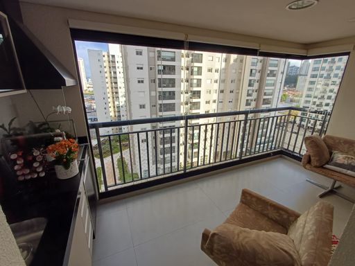 ampla varanda gourmet envidraçada com cortina blackout e churrasqueira a carvão