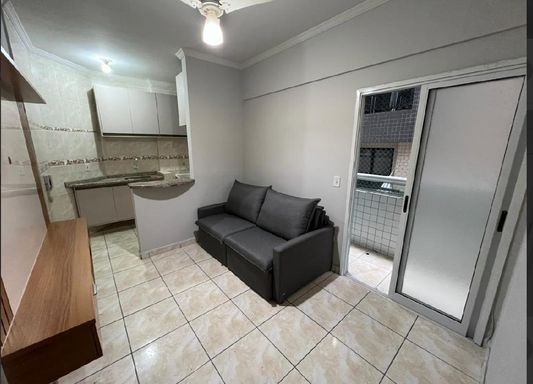 Sala semi integrada a cozinha com móveis planejados e acesso a sacada