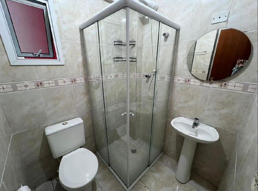 Banheiro arejado com box de vidro