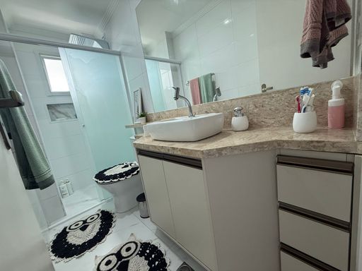 banheiro bem arejado com nicho, armário planejado e box de vidro