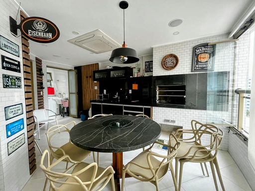 ampla varanda gourmet envidraçada com churrasqueira a carvão