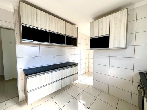 ampla cozinha arejada com iluminação natural e armários planejados