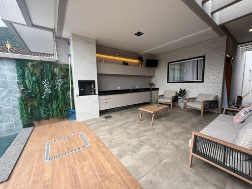 área gourmet com piscina, cascata, iluminação noturna e churrasqueira a carvão