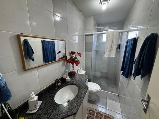 banheiro social com armário planejado e box de vidro