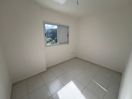 ampla suíte com iluminação natural e vista arborizada