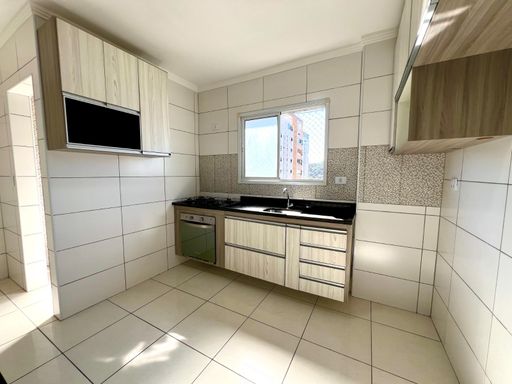 ampla cozinha arejada com iluminação natural e armários planejados