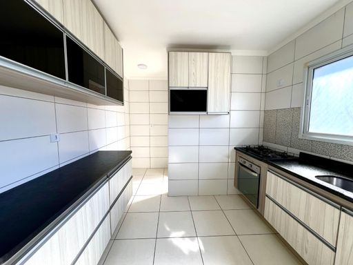 ampla cozinha arejada com iluminação natural e armários planejados