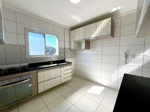ampla cozinha arejada com iluminação natural e armários planejados