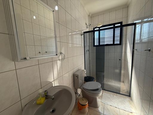 banheiro social bem arejado com box de vidro