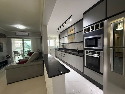 sala ampla 2 ambientes, semi integrada a cozinha americana, com armários planejados e acesso a área de serviço bem arejada