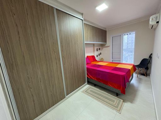 Suíte com armário planejado e acesso a varanda envidraçada