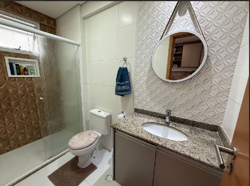 banheiro da suíte com armário planejado, box de vidro e nicho, bem arejado