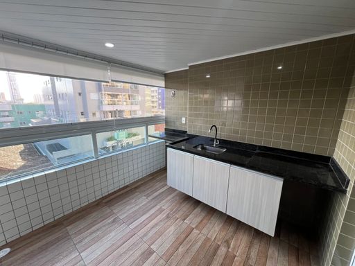 ampla varanda gourmet envidraçada com cortina blackout, acesso a sala 2 ambientes e a suíte