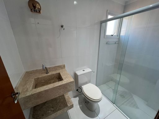 banheiro social bem arejado com box de vidro