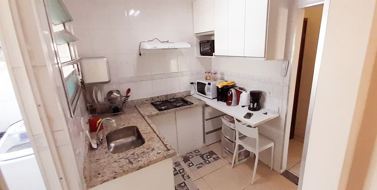 cozinha com armários planejados e ampla pia de granito em L