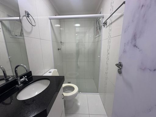 Banheiro com armário planejado e box de vidro