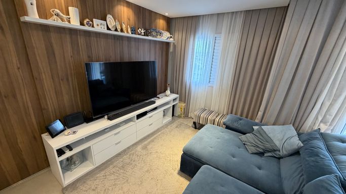 Sala ampla com painel e móveis planejados