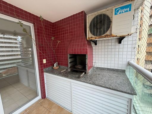 ampla varanda gourmet com churrasqueira a carvão e tela de proteção