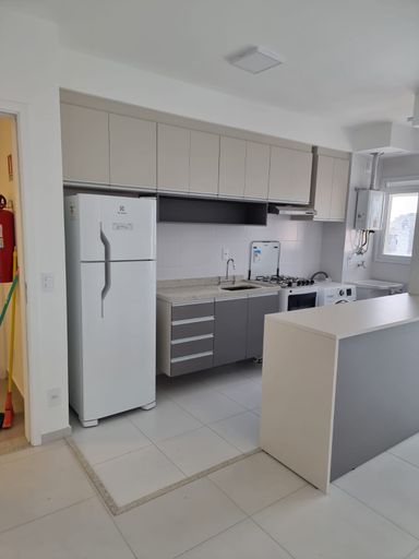 Cozinha com móveis planejados semi integrada a área de serviço bem arejada