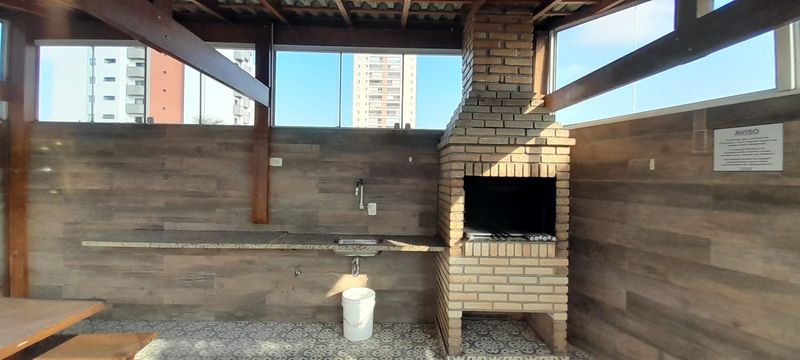 espaço gourmet envidraçado com churrasqueira a carvão