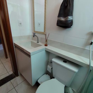 banheiro bem arejado com armário planejado e box de vidro