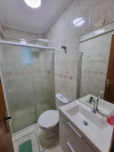 Banheiro arejado com armário planejado e box de vidro