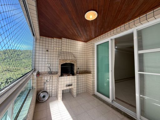 varanda gourmet envidraçada com vista para o morro do Xixová, churrasqueira a carvão e tela de proteção