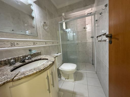 banheiro da suíte 1 com box de vidro bem arejado