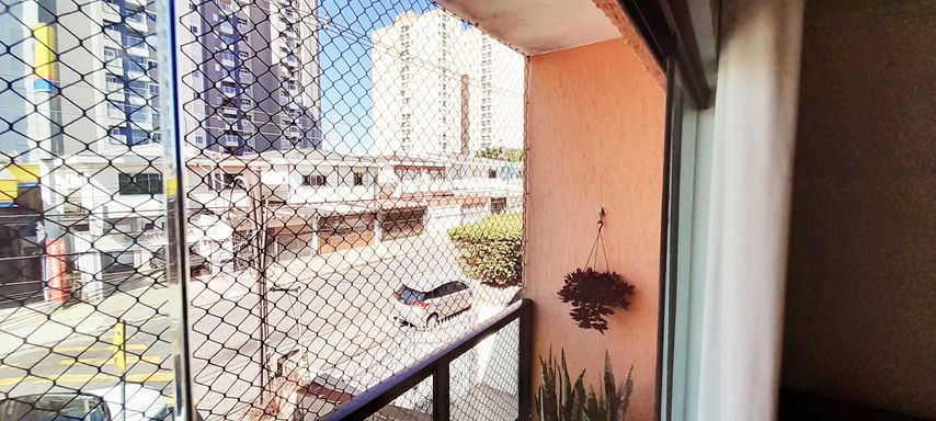 ampla sacada com porta de correr de vidro e tela de proteção, vista privilegiada de frente para rua principal
