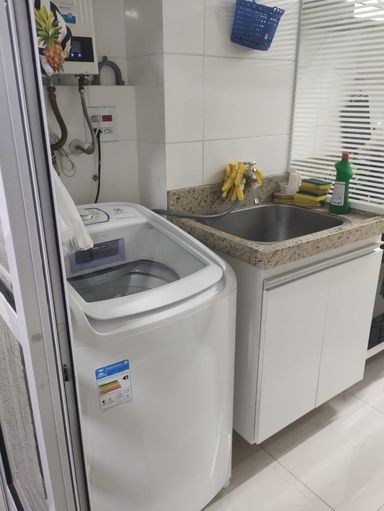 área de serviço semi integrada a cozinha, com armário planejado bem arejada