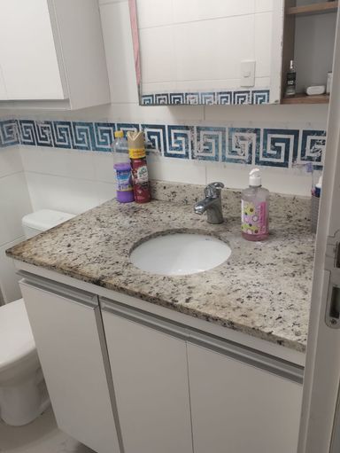 banheiro da suíte com armário planejado e pia em granito