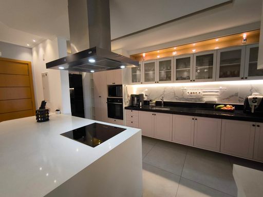 balcão da cozinha com cooktop, coifa e linda iluminação.