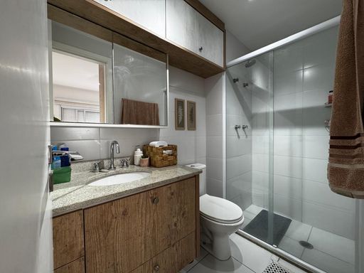 banheiro da suíte com armários planejados e box de vidro