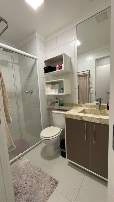 banheiro da suíte com box de vidro e armário planejado